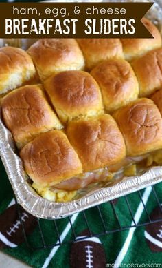 ham, egg and cheese breakfast sliders in a baking pan on a green towel