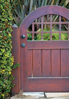 an old wooden gate is surrounded by greenery