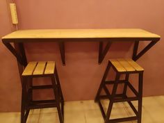 two wooden stools and a table in a room