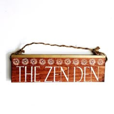 a wooden sign with the word the zenden written in white on top of it