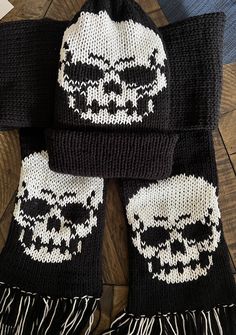 a knitted skull hat and scarf sitting on top of a wooden floor