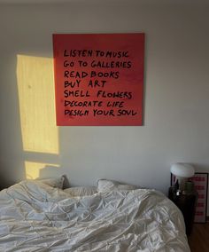 a bed with white sheets and a red sign on the wall above it that says listen to music go to gallerys dead books