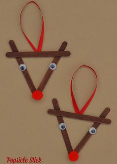 two reindeer ornament made out of sticks and yarn with eyes on them for christmas