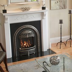 a living room filled with furniture and a fire place in front of a mirror on the wall