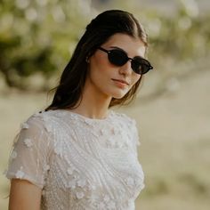 a woman wearing sunglasses and a white dress