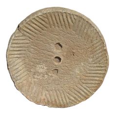 an old coin with two holes in the middle and one hole at the bottom, on a white background