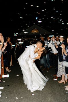 a bride and groom kissing in front of bubbles