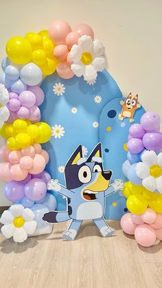 the balloon arch is decorated with flowers and an image of cartoon character in front of it