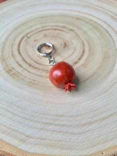 a small red object sitting on top of a piece of wood next to a pair of scissors