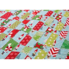 a close up of a quilted table cloth with christmas trees and snowflakes on it