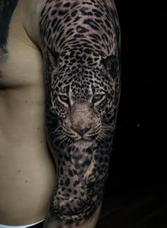 a man's arm with a black and white tattoo on it, depicting a leopard