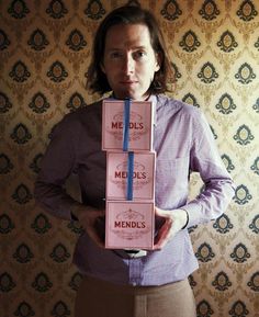 a woman standing in front of a wall with three boxes stacked on her head and the words meds, meds, and mendls