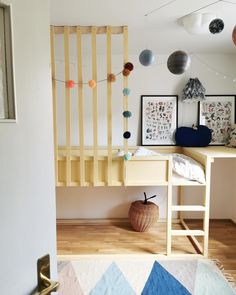 a room with a desk, stairs and pictures hanging on the wall in front of it