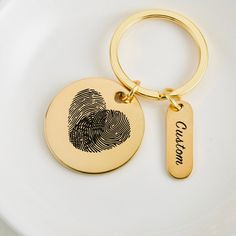 a gold plate with a fingerprint keychain and a name tag on it