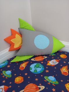 a child's bed with space themed sheets and pillows