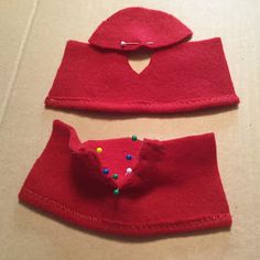 two pieces of red felt with colorful beads on them and one piece has a hat attached to it