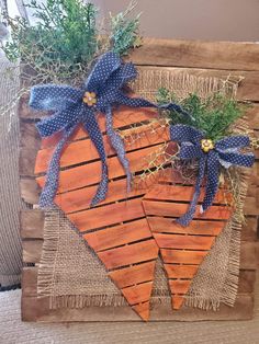 a wooden sign that has some plants on top of it and blue ribbon around the edges