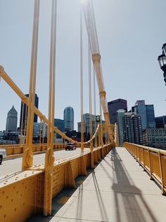 the sun shines brightly on a bridge with cars driving across it and skyscrapers in the background