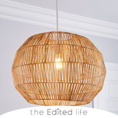 a bamboo light hanging from the ceiling in a room with white walls and trimmings