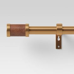 a close up view of the handle on a curtain rod with leather linings and brass finish