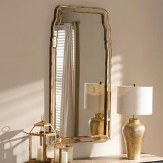 a mirror sitting on top of a dresser next to a lamp