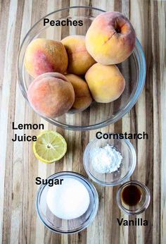 peaches, lemon juice, and sugar are in bowls on a wooden counter top