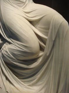 an image of a woman covered in white fabric with her hands behind her back and head tilted to the side