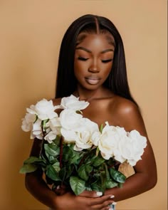 a woman with long hair holding flowers in her hands