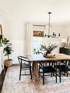 a dining room table with black chairs and a potted plant on top of it