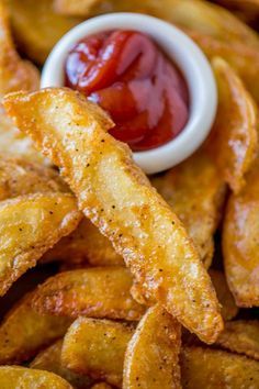 ketchup and potato wedges on a plate with ketchup in the background