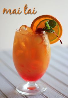 there is a drink with an orange slice on the rim and garnished with mint