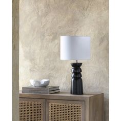 a table lamp sitting on top of a wooden cabinet