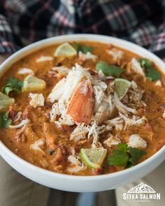 a person holding a bowl of lobster and rice soup