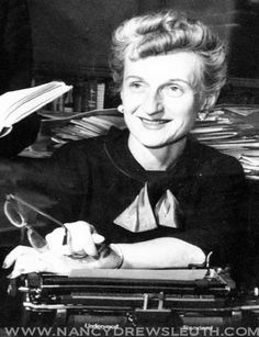 an old black and white photo of a woman sitting at a desk with a typewriter