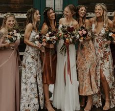 a group of women standing next to each other holding bouquets in their hands and smiling