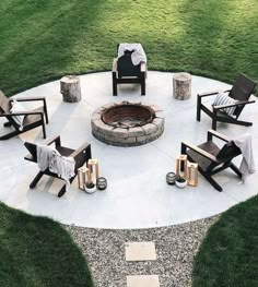 an outdoor fire pit surrounded by chairs and tables