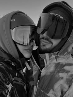 a man and woman with ski goggles on