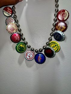 a person holding onto a necklace made out of beer bottle caps