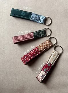 four keychains with different designs on them sitting next to each other in the shape of umbrellas