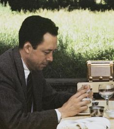 a man sitting at a table looking at his cell phone