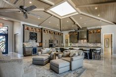 a living room filled with lots of furniture and a ceiling fan in the middle of it