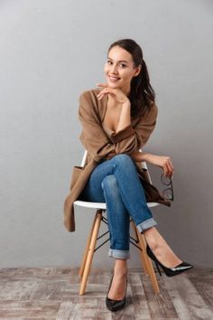 a woman sitting on top of a white chair