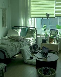 a laptop computer sitting on top of a bed in a room filled with green furniture