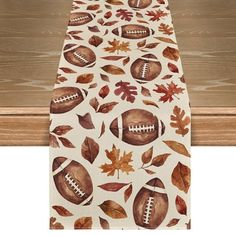 an ironing board covered in fall leaves and footballs on white paper with brown trim