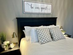 a bedroom with a bed, nightstands and a sign on the wall above it