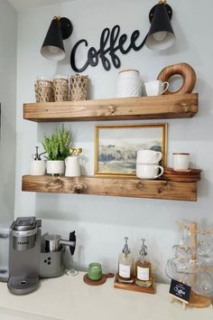 two shelves with coffee cups and other items on them in a small kitchen area next to a counter