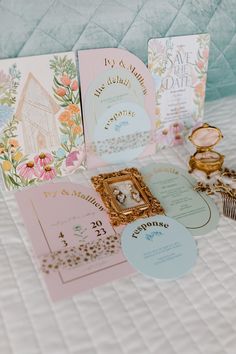 the wedding stationery is laid out on top of the bed, including cards and rings