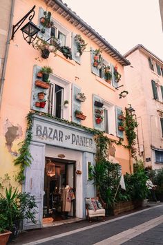 an old building with plants growing on the windows and shutters that read bazah or panne