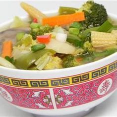 a bowl filled with soup and vegetables on top of a table