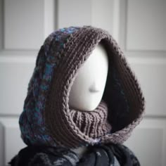 a mannequin's head wearing a knitted hat with a scarf around it